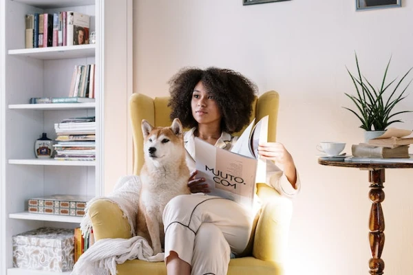 a woman reading with her dog at home